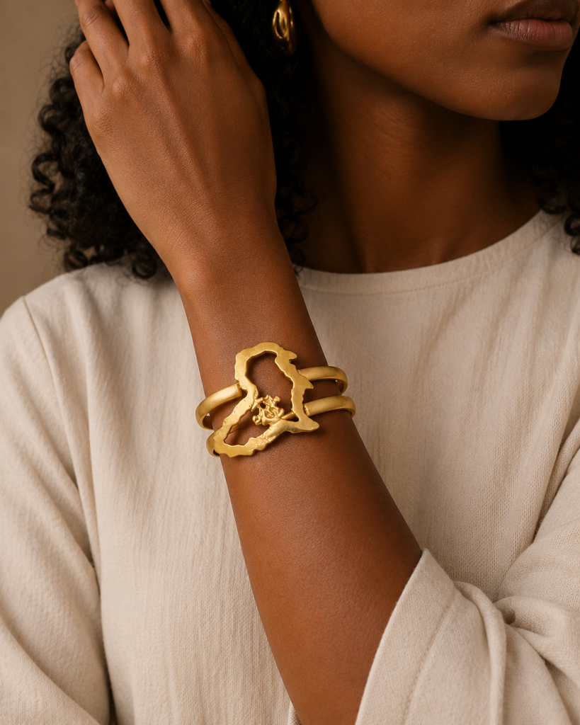 femme qui porte un bracelet en bronze doré avec milieu en forme de carte d'Afrique et symbole Adinkra Nyame