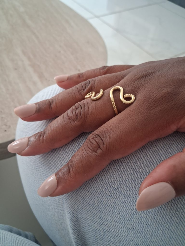 bague Aya bijou de forme organique portée main posée sur la jambe pantalon jean
